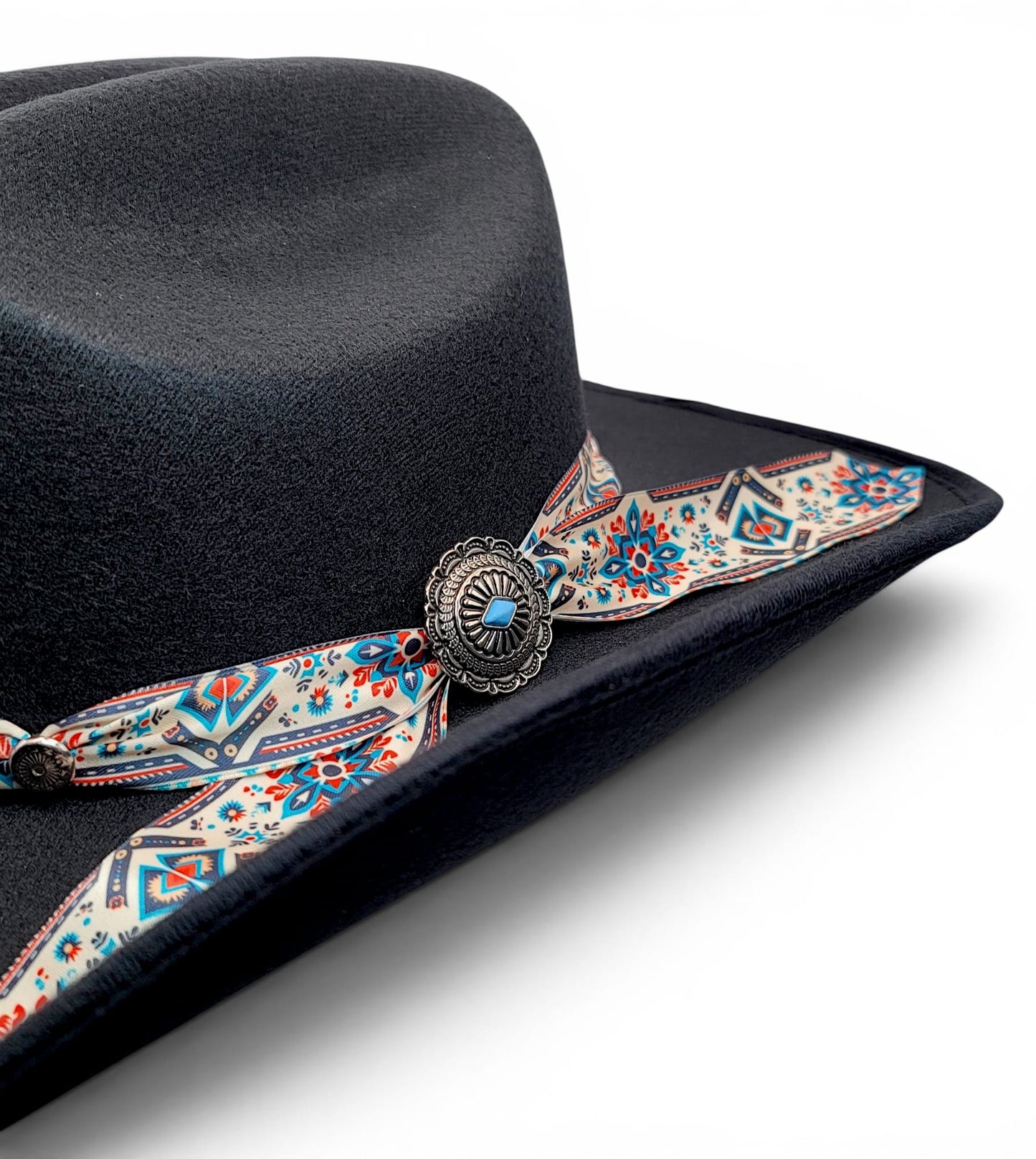 Close-up of patterned Charlie hat band and silver-tone concho on women’s black cowgirl hat