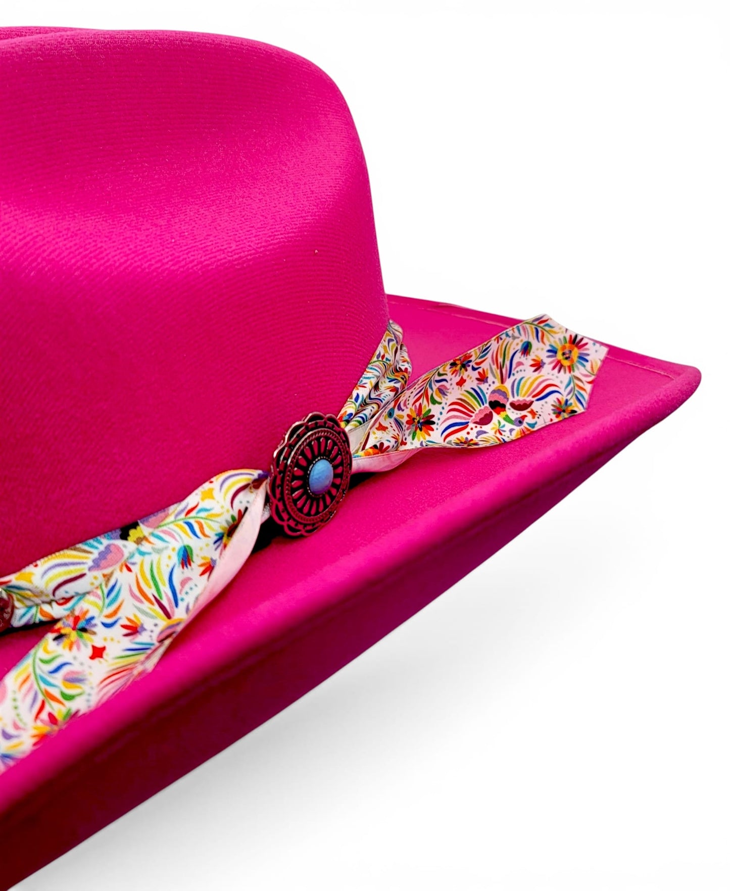 Close-up of floral Charlie hat band and silver-tone concho on women’s fuchsia cowgirl hat