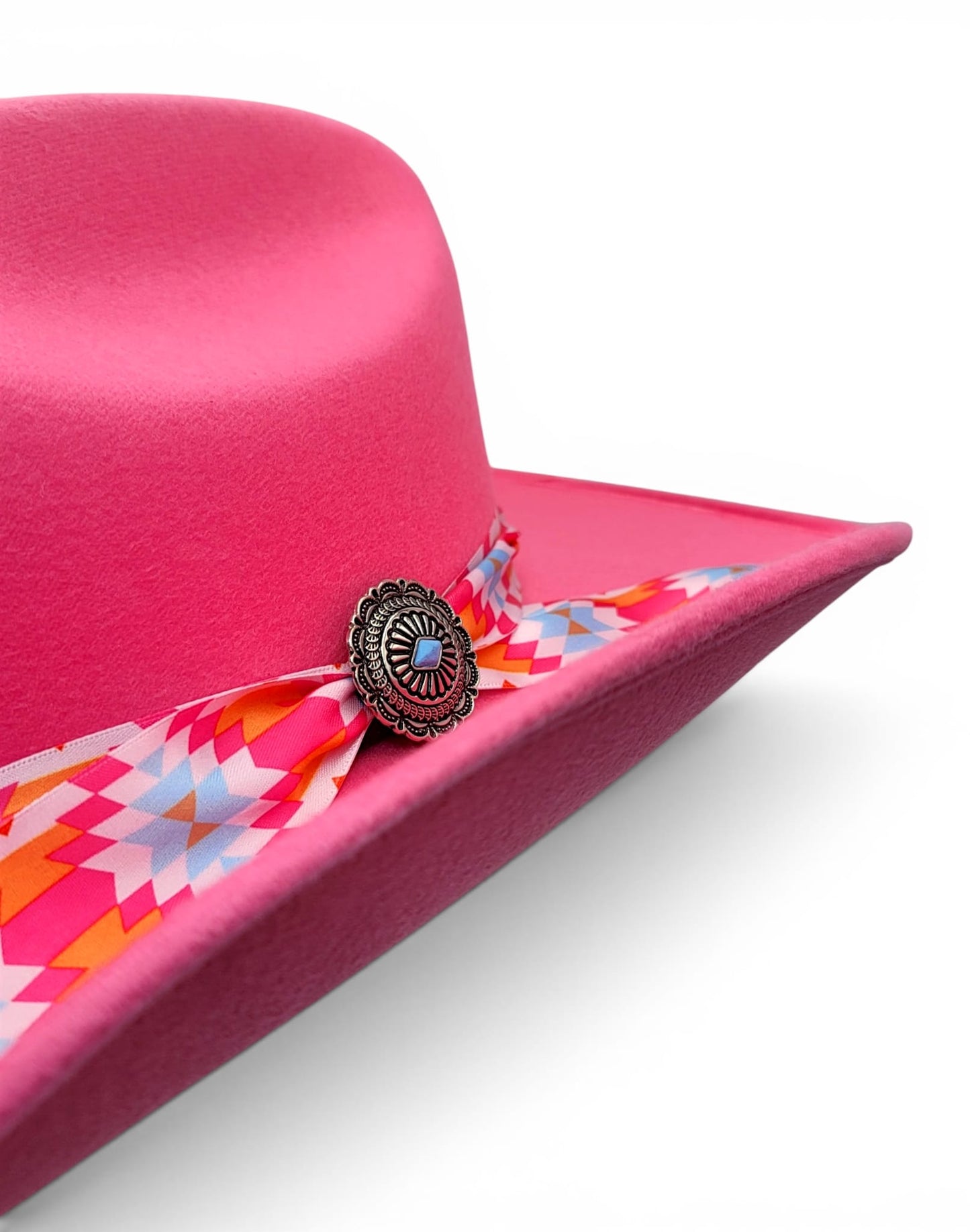 Close-up of Charlie hat band and silver-tone concho on women’s pink cowgirl hat