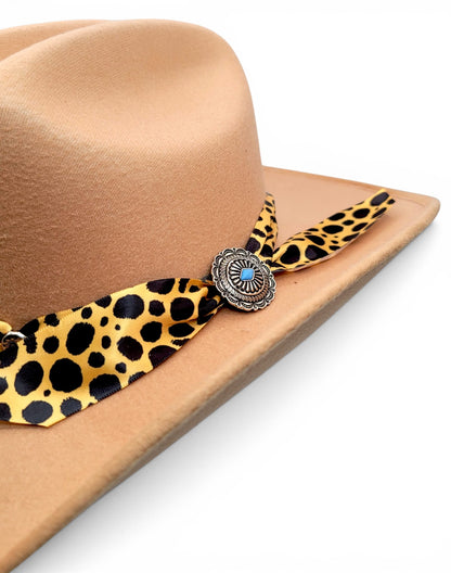 Close-up of animal-print Charlie hat band and silver-tone concho on women’s tan cowgirl hat